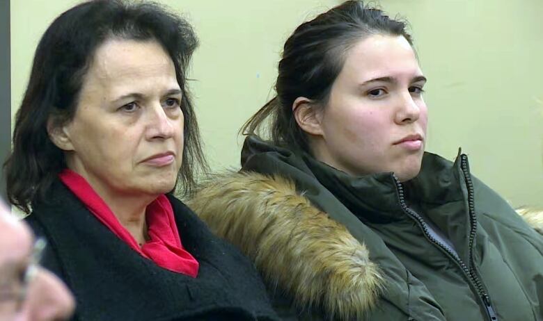 two women sitting in their coats