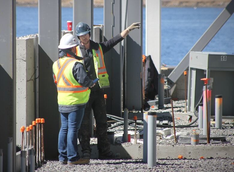 Workers discuss plans at the new Marconi campus of Nova Scotia Community College under construction in downtown Sydney.