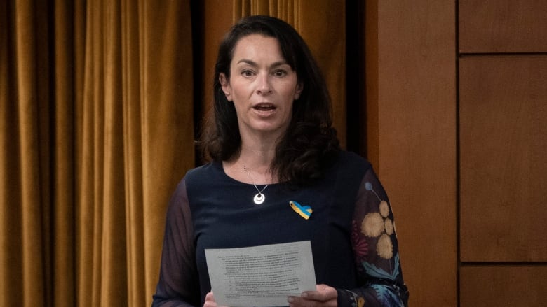 A politician holding a piece of paper. 