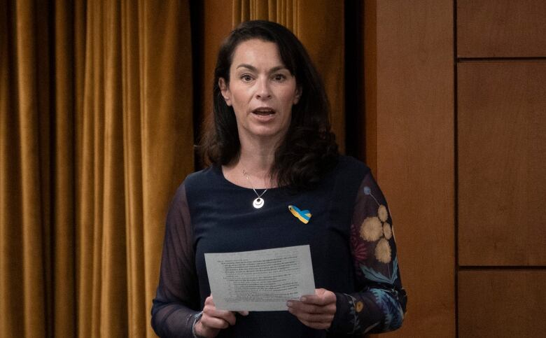 A politician holding a piece of paper. 