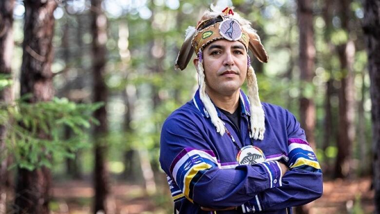 A man wearing an Indigenous headdress. 