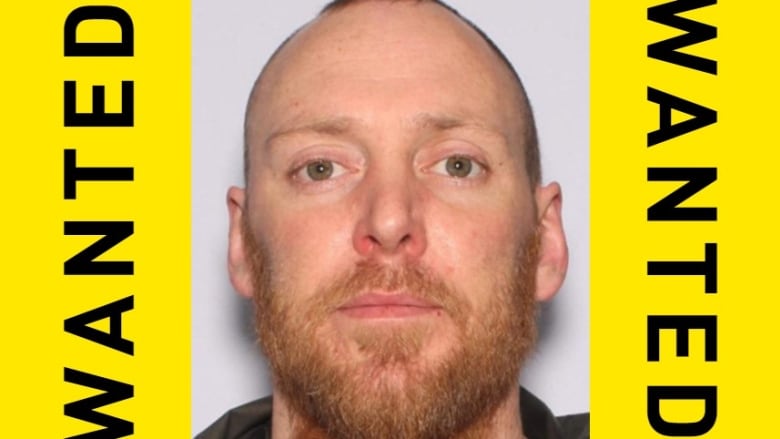 A man with beard is pictured with a frame that reads 'Gene Karl Lahrkamp wanted for murder.'