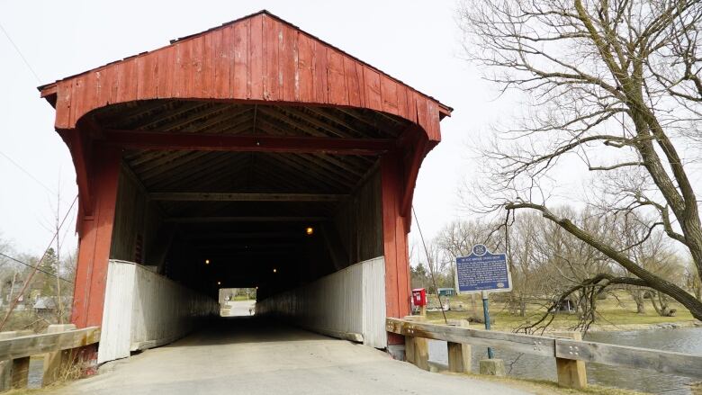 A bridge with red wood cladding and a roof