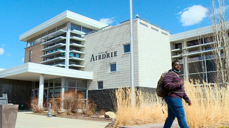 A person walks by a city hall building.