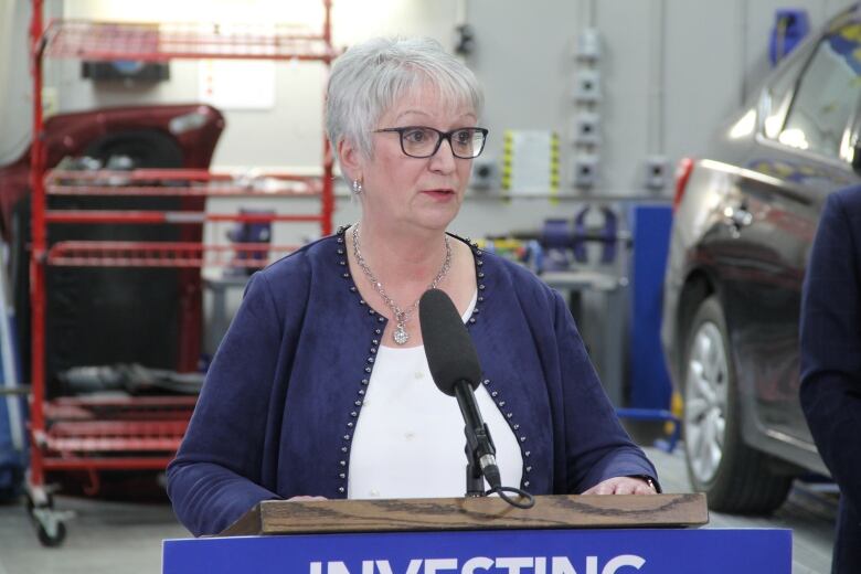 A woman stands at a podium.