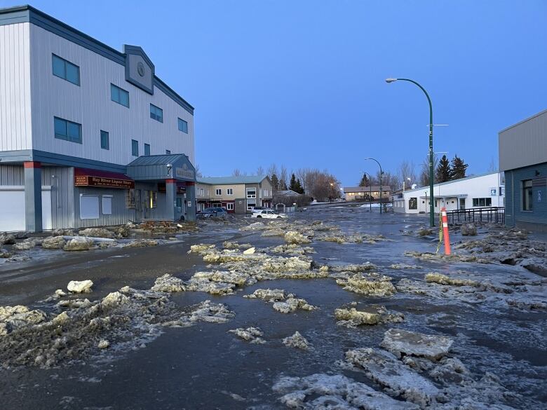 A street has water and ice sitting in it. 