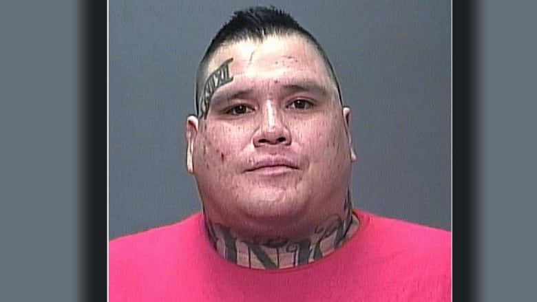 mug shot of man with tattoo