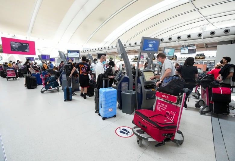 A group of people lined up waiting to check in to a flight.