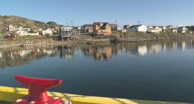 Homes are seen dotting the shoreline of a body of water.