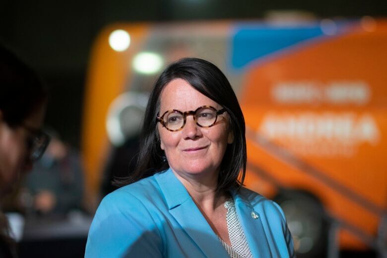 woman stands in front of NDP sign