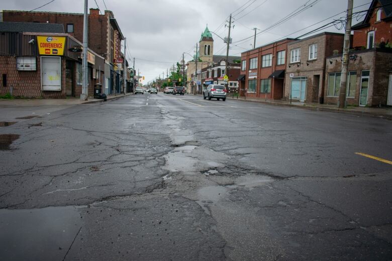 Road with widespread cracking and major potholes. 