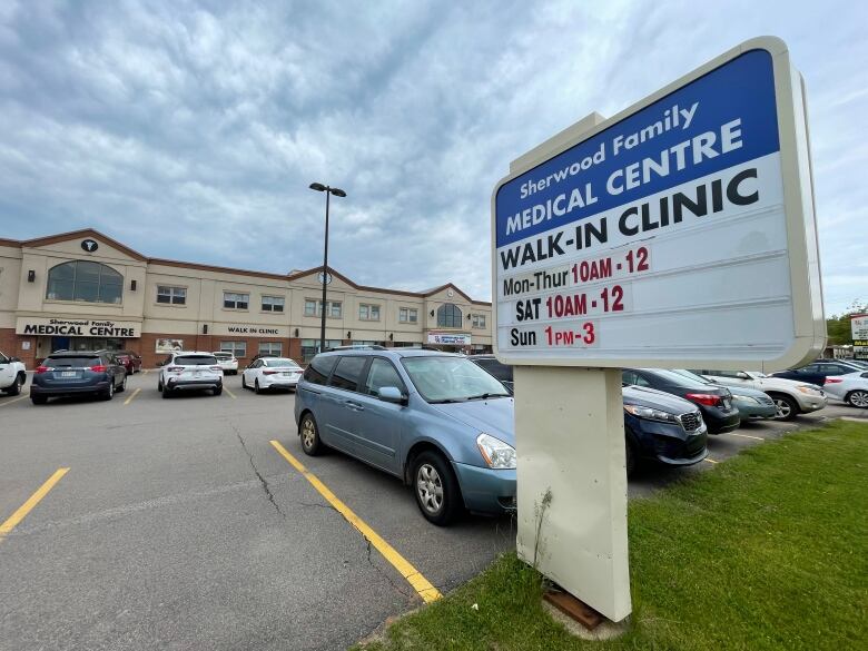 Sign outside a medical clinic listing its hours of operation. 