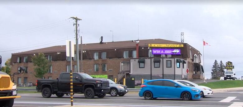 A photo from across the street of a large brown motel