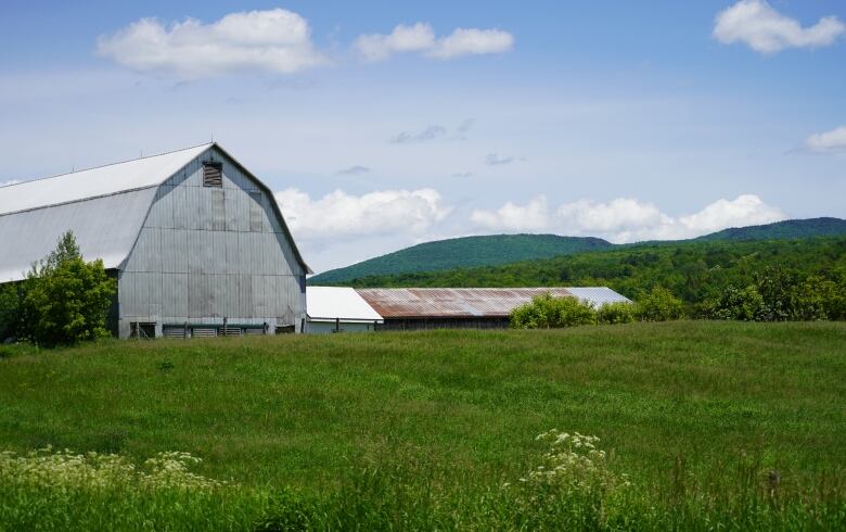 A big barn looms over rolling farmland.