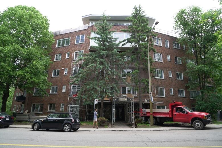 A view of the five-storey, brick apartment from the outside, where construction work continues.