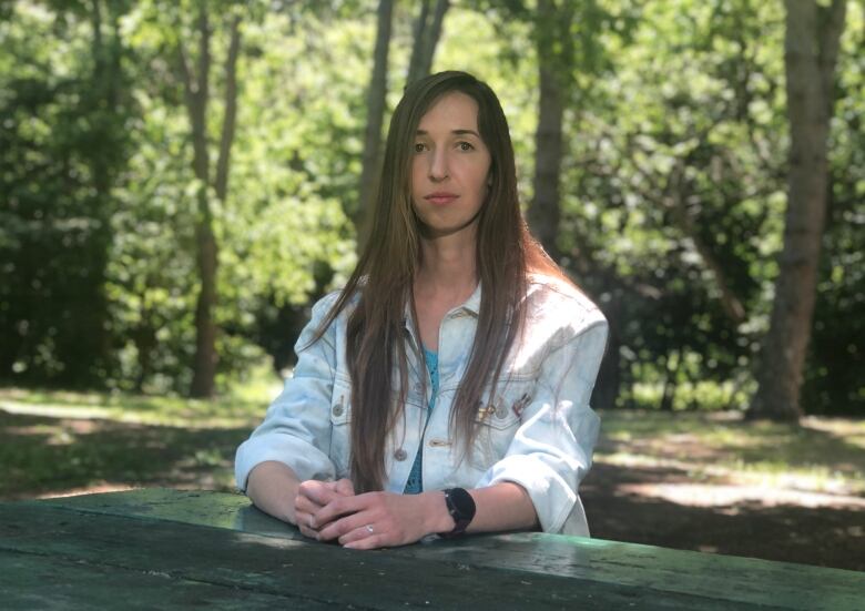 A young woman sits at a picnic table in a Toronto park. 