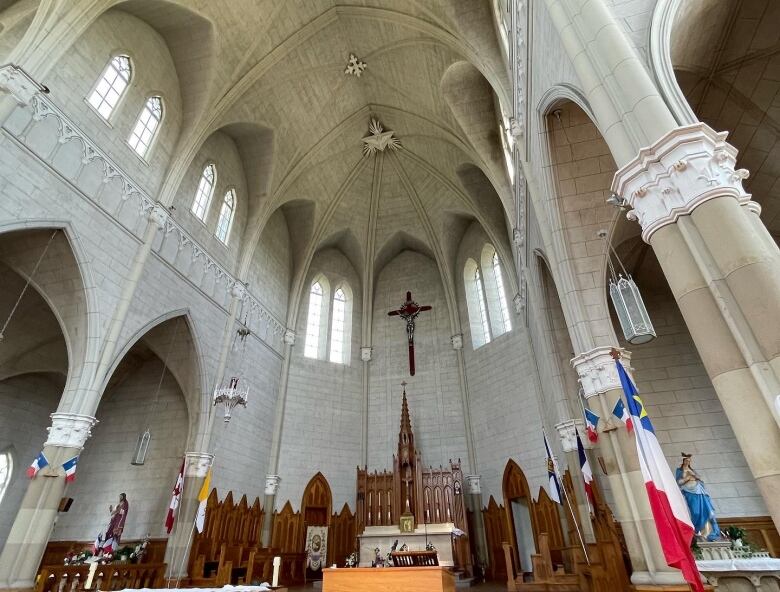 Gothic style church interior showing the ceiling and altar.