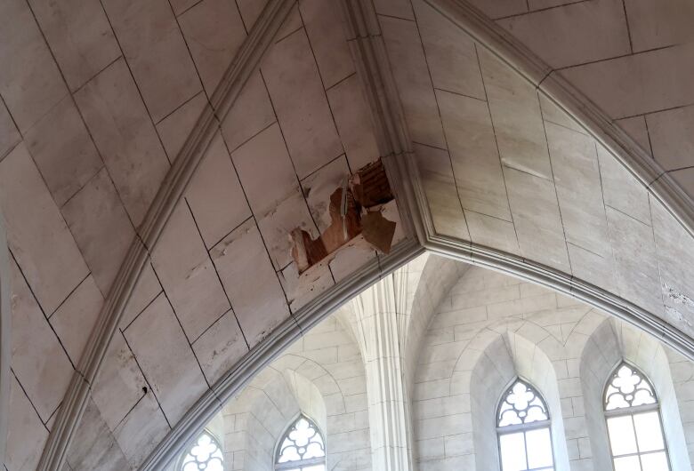 Photo of crumbling plaster on church ceiling.