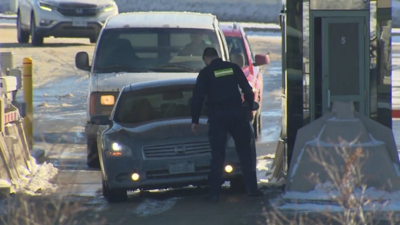 An agent of the Canada Border Services Agency inspects a vehicle entering Canada at the Rainbow Bridge Border Crossing in Niagara Falls, Ont. (Andy Hincenbergs/CBC)