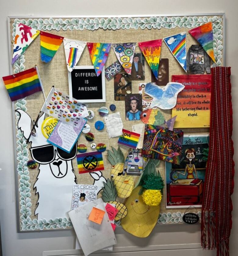 This picture is of a school bulletin board that features Pride flags and sayings, like love is love.