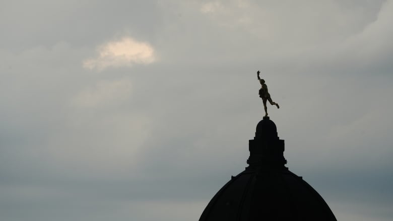 Dark clouds move over the Golden Boy atop the Manitoba Legislative Building in Winnipeg.