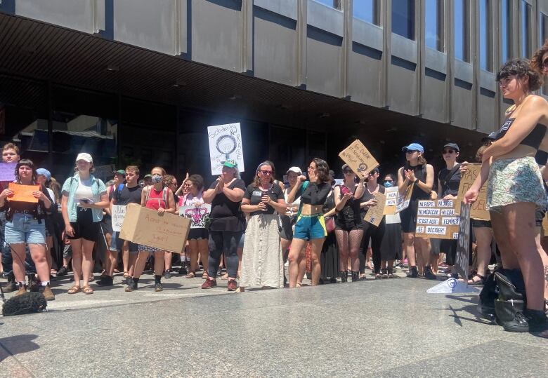 A crowd of people carrying pro-choice signs is gathered in front of the Montreal courthouse.