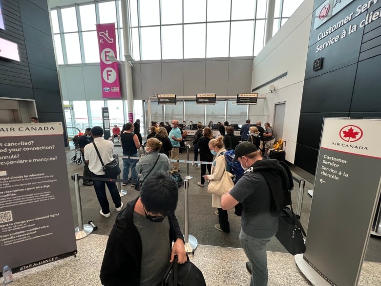 A lineup at the Pearson airport customer service desk after many cancellations.