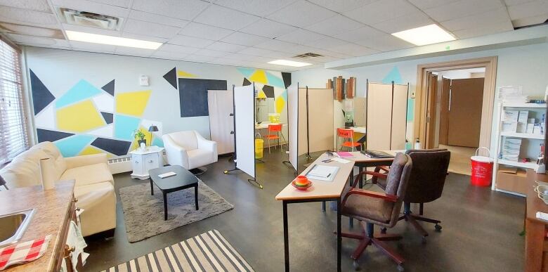 Interior shot of room with couches and tables plus drug consumption cubicles