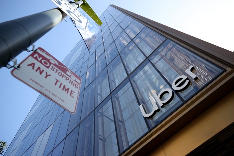 A highrise office building with the Uber logo on an outside window.