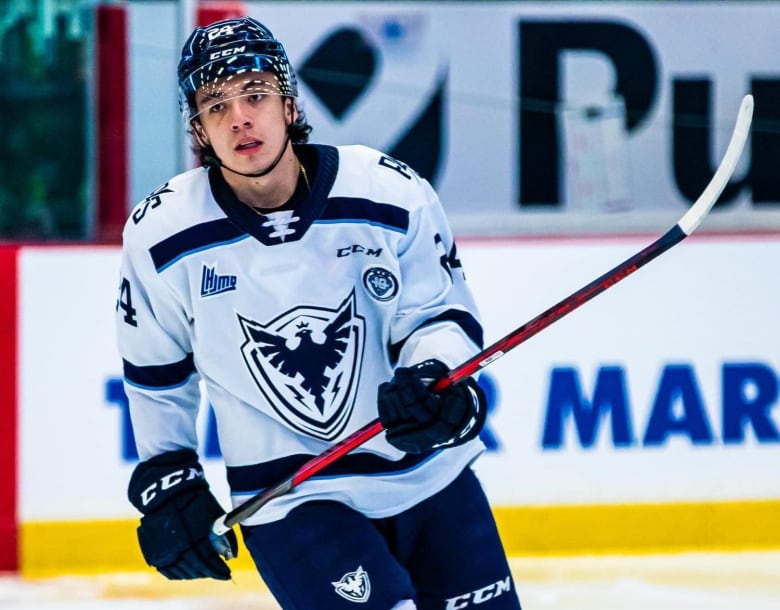 A Cree hockey player in uniform for a Quebec Major Junior Hockey League team, the Sherbrooke Phoenix skates towards the camera.