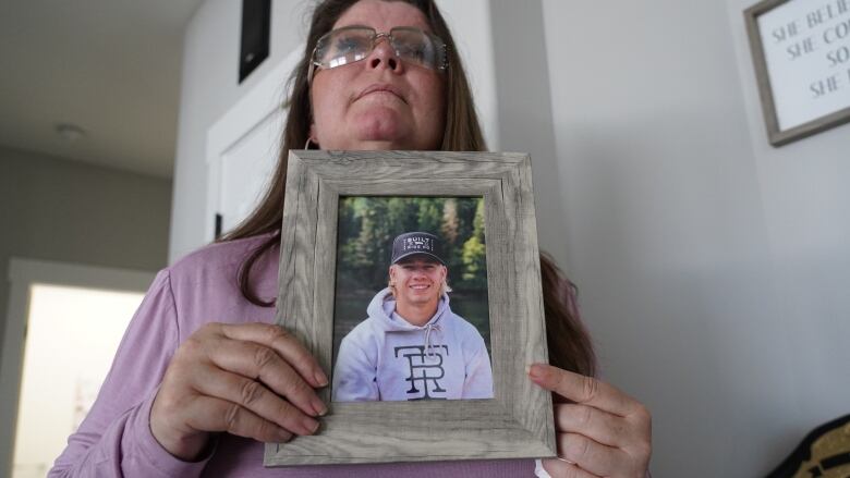 Danielle Pritchett holds a photo of her son, Cailen Vilness, who was killed in a 2021 construction crane collapse in Kelowna, B.C. July 11, 2022.