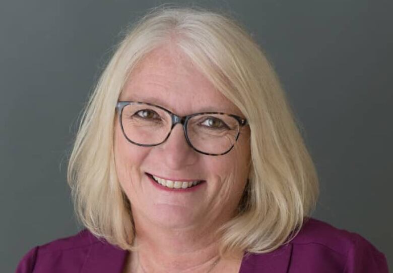 Portrait of a smiling woman with glasses.