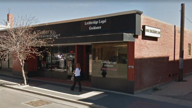 A brick building with a glass storefront reading 