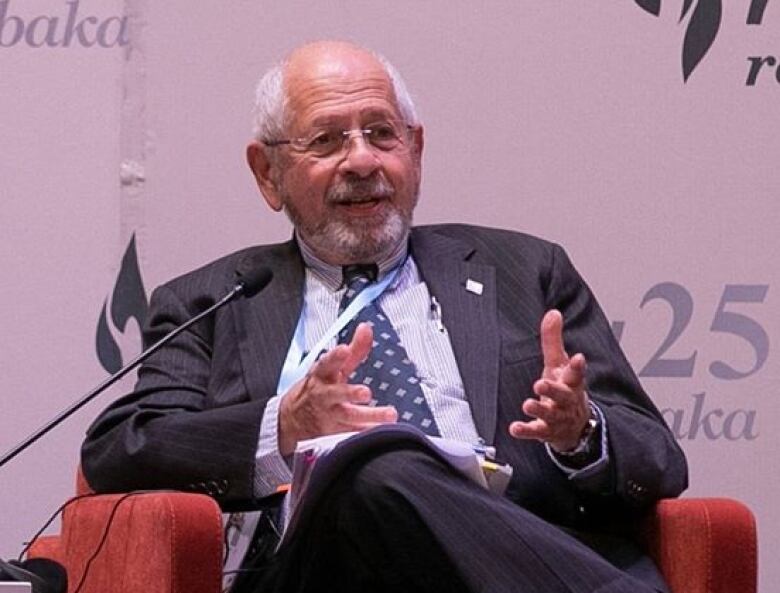 Professor Frank Chalk lecturing on a red chair.