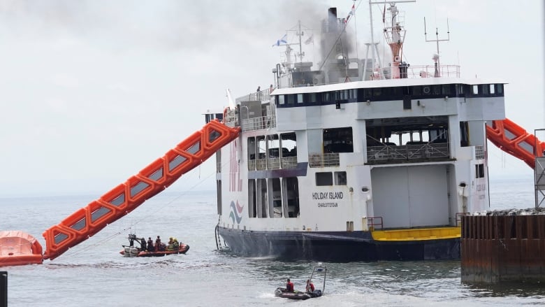 Fire fighters approach the MV Holiday Island ferry after a fire broke out on it.