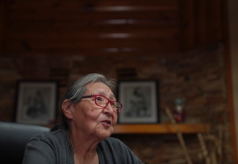 A woman sits at a desk.