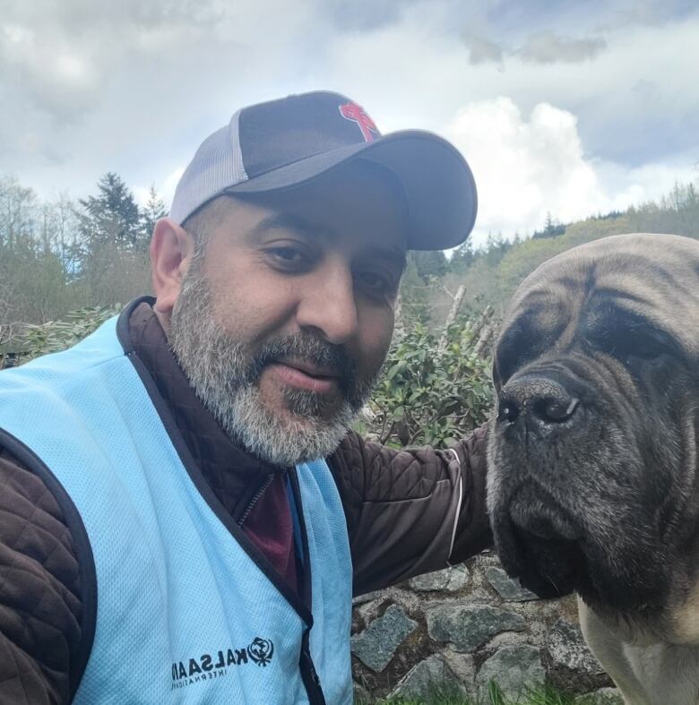 Mike Minhas next to a large dog.