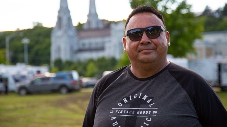 A man stands in front of a church.