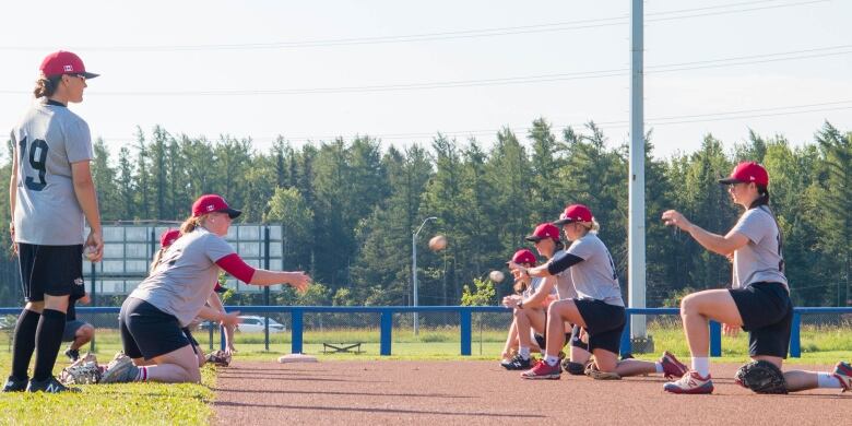 Players with the national Canadian women's baseball team run through drills at a baseball diamond in Thunder Bay, Ont.