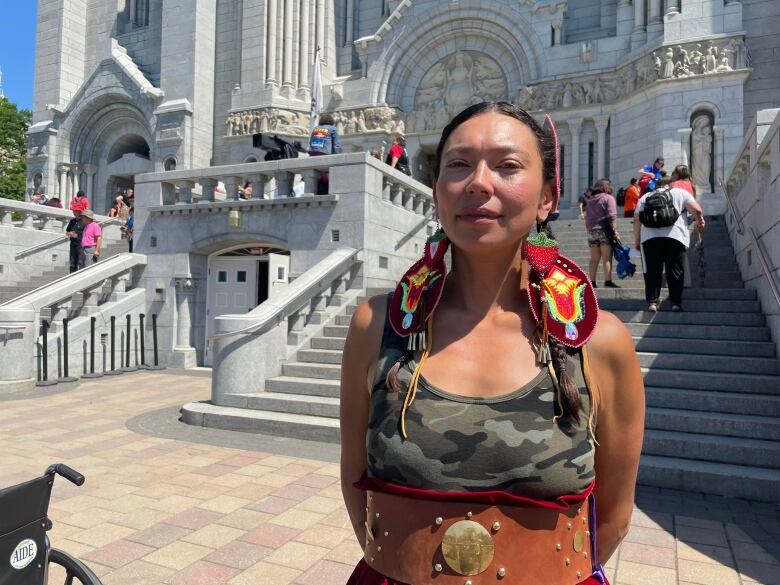 Woman stands in front of a church. 