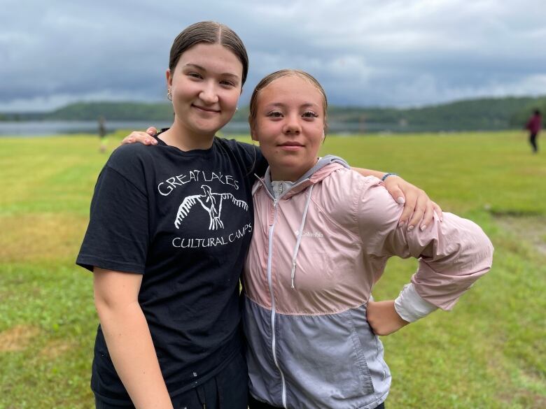 Two teenage girls posing outside.