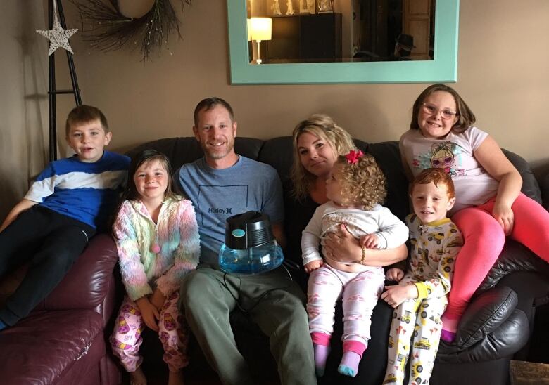 A family sit in their living room.