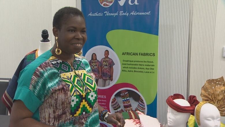 A Black woman with short dark hair in a colourful short sleeved top