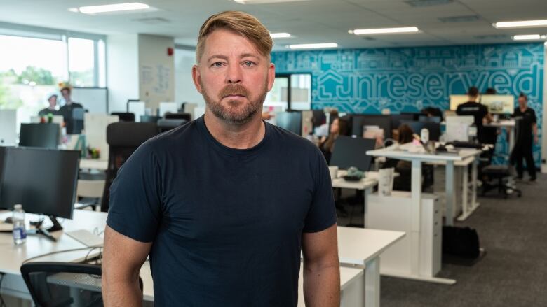 A company executive poses for a photo in an office.