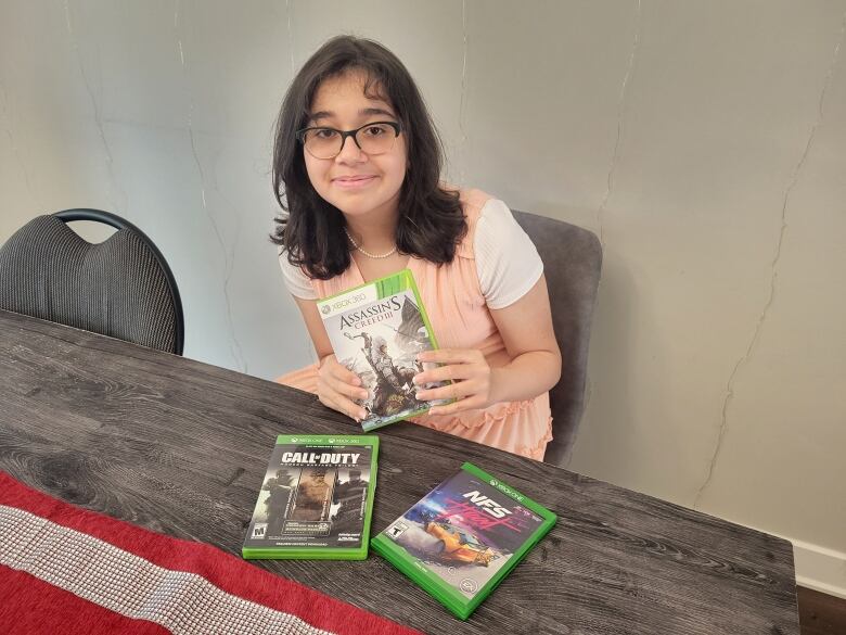 A teenage girl holds one of her favourite Xbox 360 video games. 