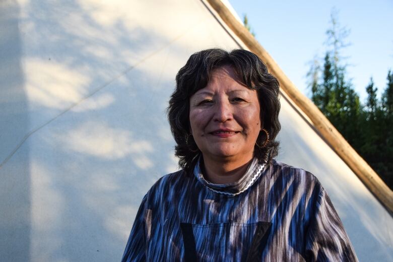 Portrait of woman in front of canvas tent.