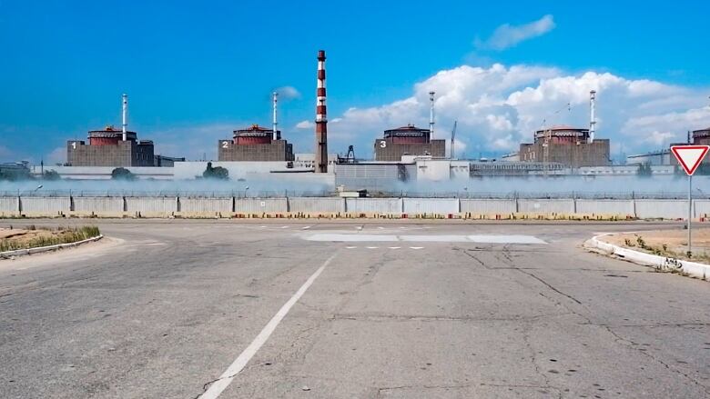 A nuclear plant is seen in the distance with a road in the foreground.