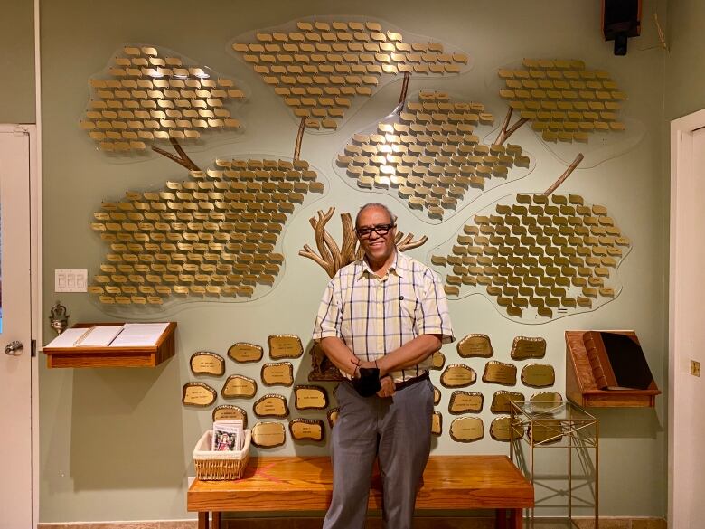 man standing in front of donation plaques. 