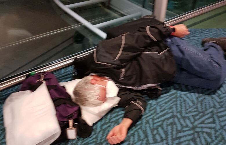 Frank Michel sleeping on the floor at the airport.