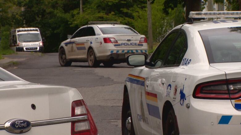 Three RCMP vehicles parked alongside a street.